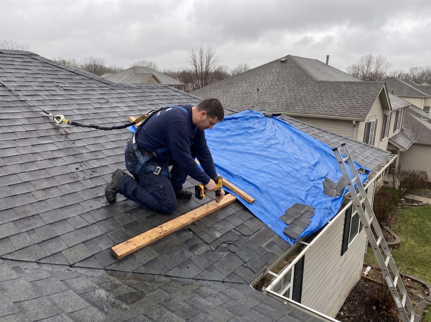 The Roofing Pro securing an emergency tarp on a storm-damaged roof